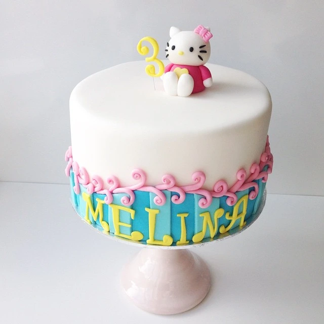 A beautifully decorated Hello Kitty cake with pink frosting, a white fondant Hello Kitty face, and a bow on top, perfect for birthdays and celebrations.