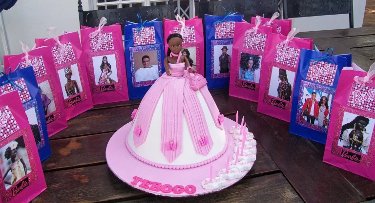 A beautifully decorated Barbie cake featuring a doll surrounded by layers of frosting designed to look like a ball gown.