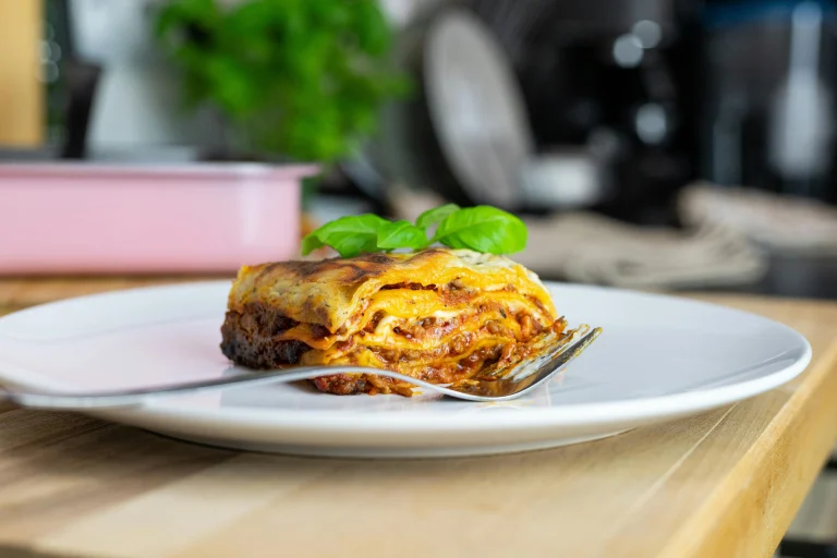 A freshly baked Barilla lasagna with golden, bubbly cheese on top, layered with rich meat sauce and pasta sheets, served in a white casserole dish