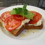 Quick and delicious avocado and tomato toast on sourdough for a healthy breakfast option.