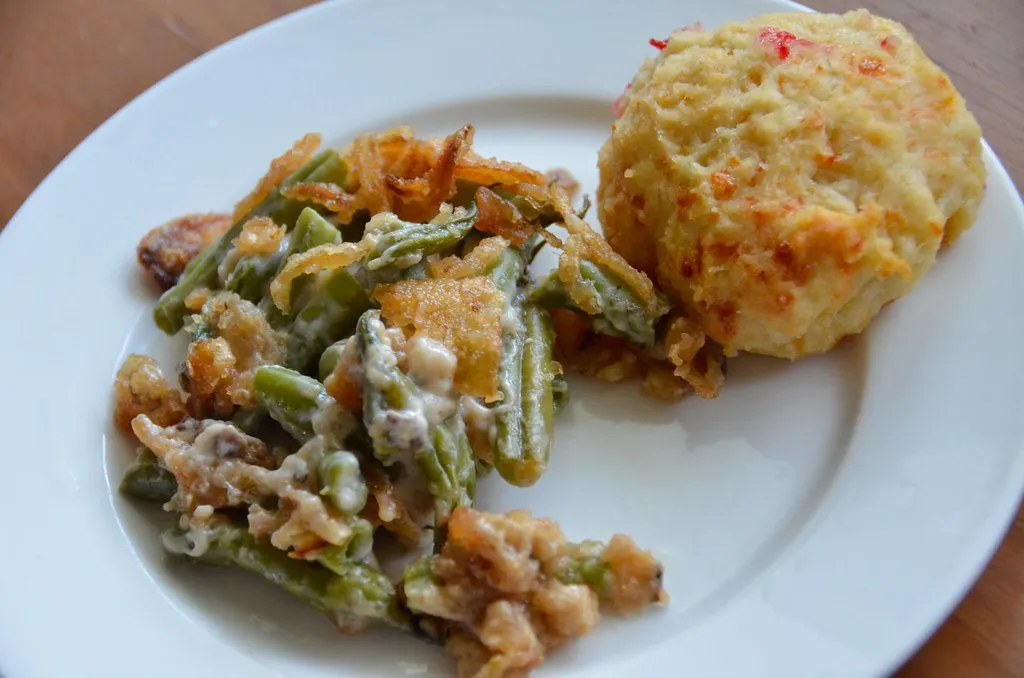 A plated serving of the biscuit breakfast casserole, cut into neat portions with a garnish, perhaps paired with hash browns or a side of fruit