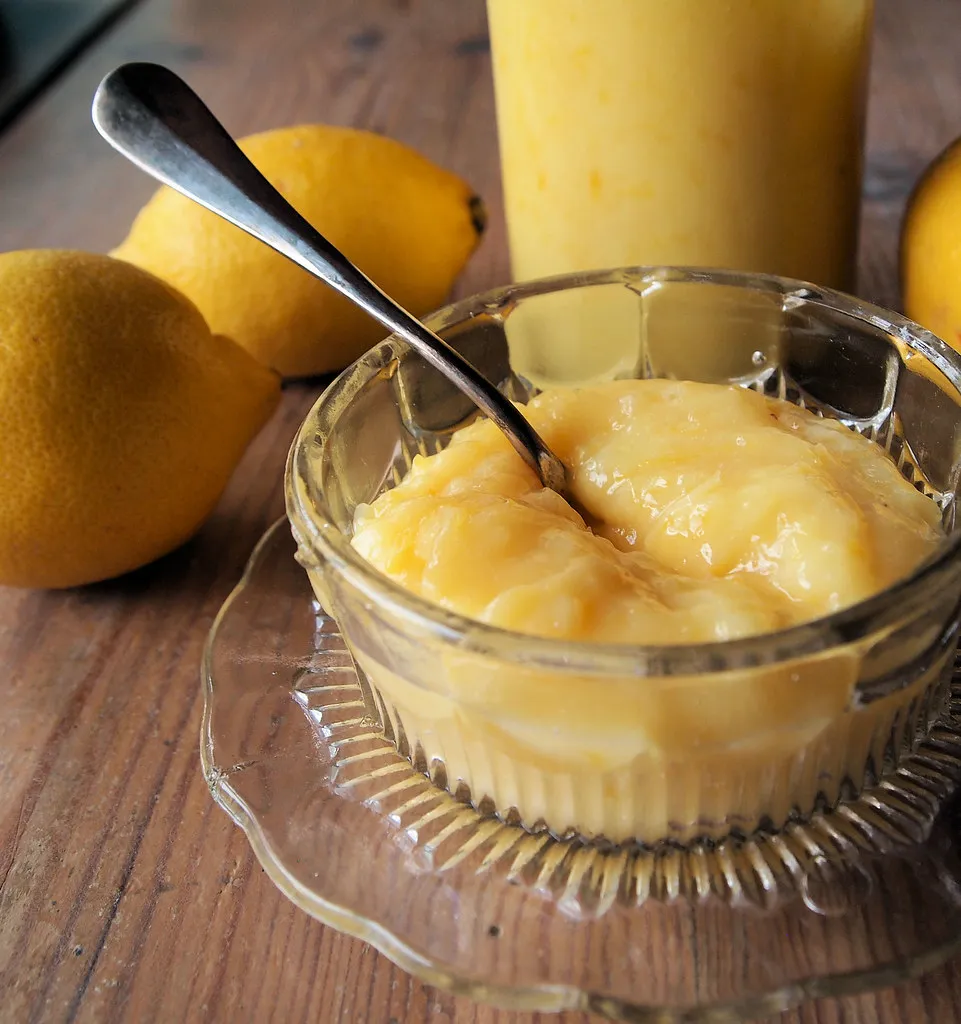 Smooth and creamy homemade lemon pie filling in a glass bowl, ready for layering with angel food cake