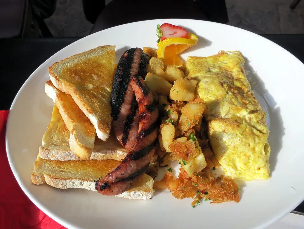 Homemade breakfast sausage patties served with scrambled eggs and toast on a white plate.