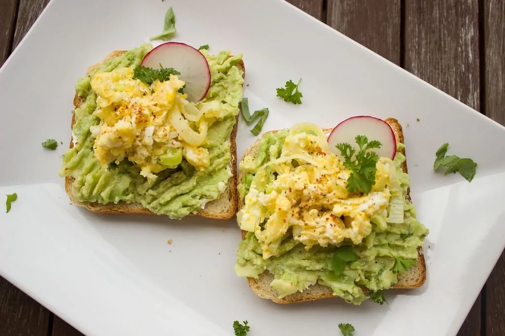 A high-protein breakfast plate with eggs, whole grain crackers, and cheese slices.