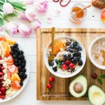 A creamy yogurt bowl topped with fresh strawberries, blueberries, granola, and a drizzle of honey.