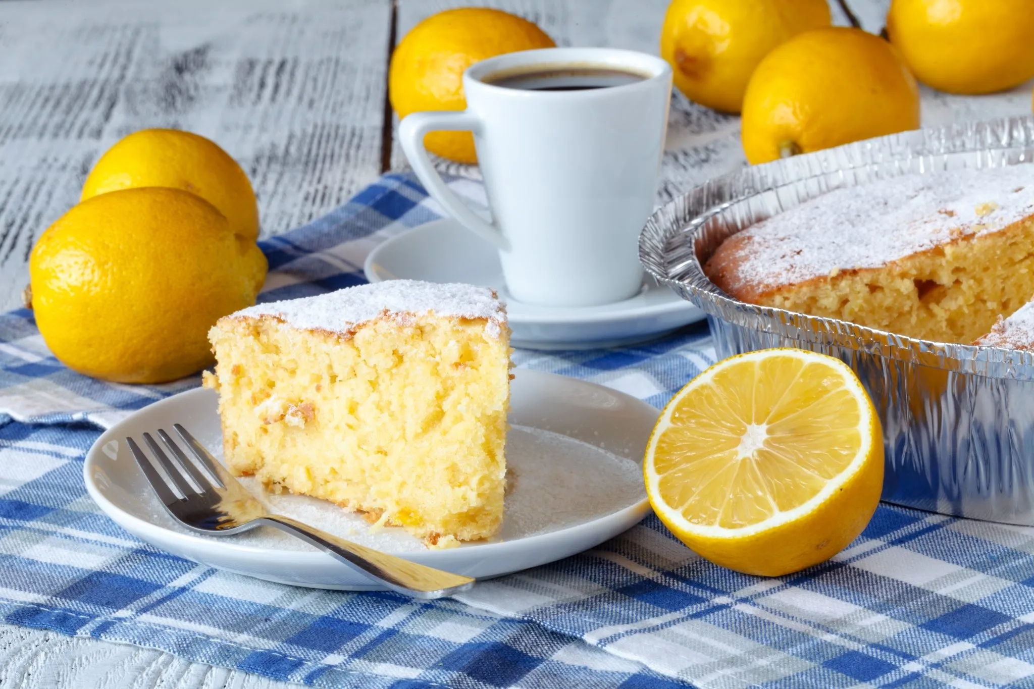 A slice of angel food cake with creamy lemon pie filling on a white plate, garnished with fresh lemon zest
