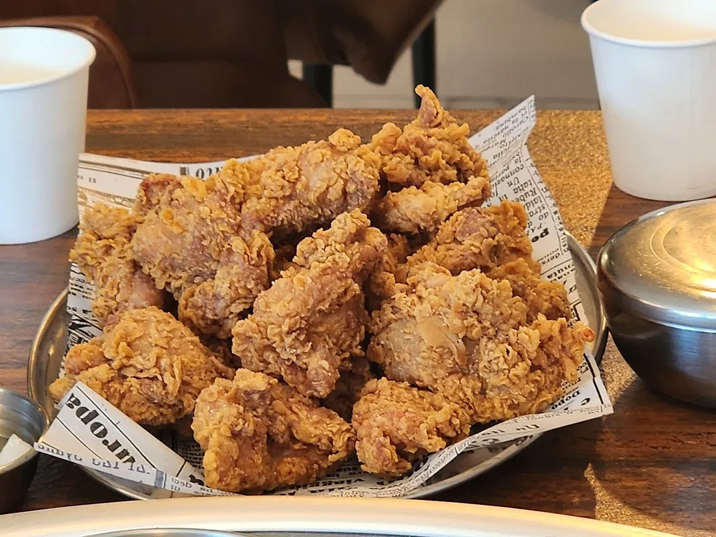 Crispy and golden Korean fried chicken coated in a flavorful sweet and spicy glaze, garnished with sesame seeds and green onions