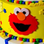 A vibrant Sesame Street-themed cake decorated with fondant characters like Elmo, Cookie Monster, and Big Bird, perfect for a children's birthday party.