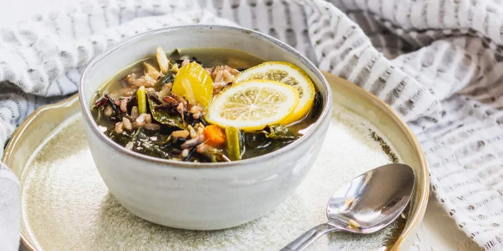 A comforting bowl of Lemon Spinach Ginger Chicken Soup with tender chicken, fresh spinach, zesty lemon, and warm ginger broth, served hot in a rustic bowl.