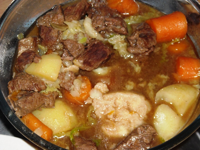 A hearty bowl of Hawaiian Beef Stew with tender beef chunks, potatoes, and carrots in a rich tomato-based broth, served alongside steamed white rice.