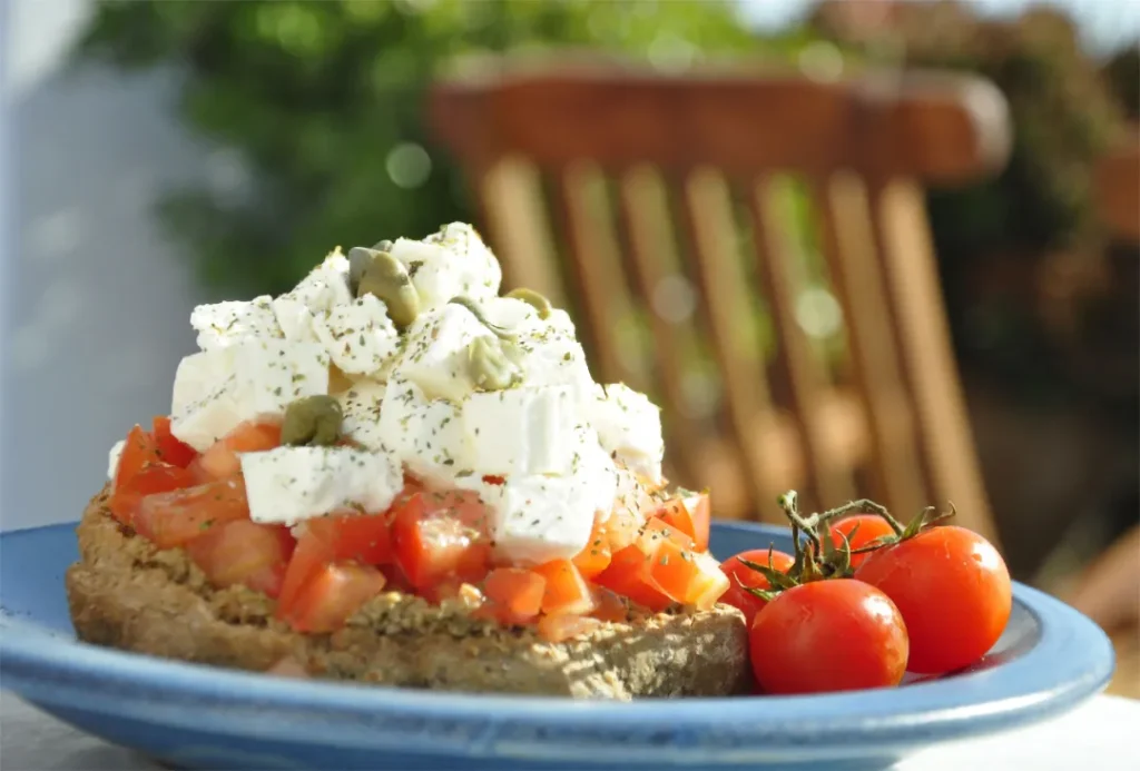 Whole wheat paximadia topped with fresh grated tomato, olive oil, and crumbled feta cheese.