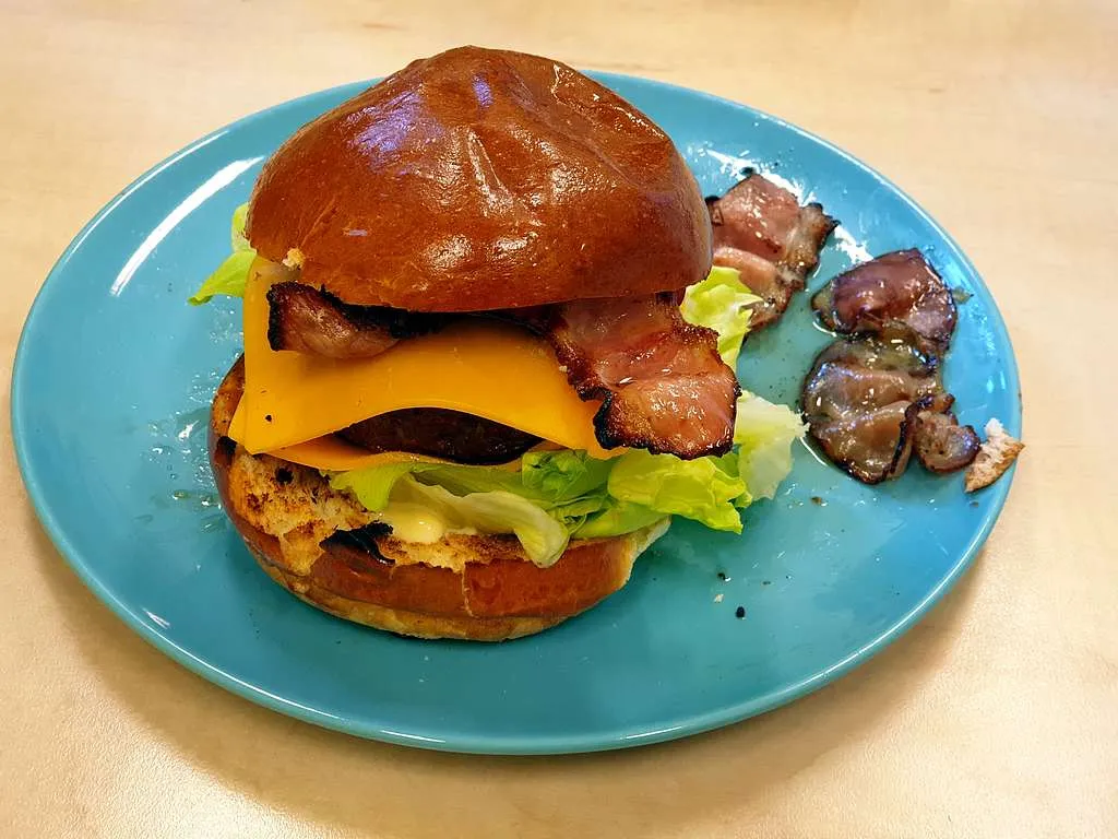 Panera-style breakfast sandwich with eggs, cheese, and bacon on a toasted brioche bun.
