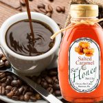 A jar of golden honey caramel with a spoon dripping thick, glossy caramel, surrounded by honeycomb and a wooden honey dipper