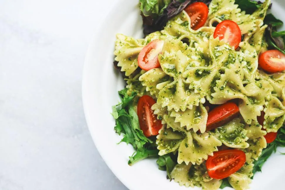 Vibrant Pasta Primavera with Roasted Vegetables, featuring penne pasta, zucchini, bell peppers, and cherry tomatoes, tossed in a light garlic butter sauce and topped with fresh basil and Pecorino Romano cheese.