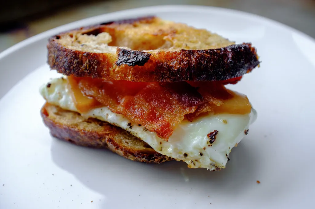 Kirkland breakfast sandwich featuring a fluffy English muffin, scrambled eggs, melted cheese, and savory sausage patty, perfect for a quick and delicious morning meal