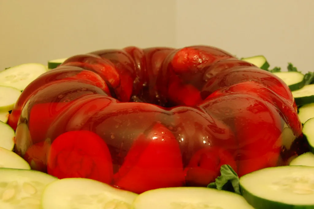 Cranberry Jello salad served in a glass dish with whipped topping