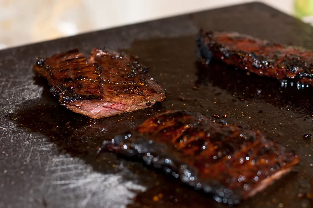 Perfectly cooked skirt steak sliced on a cutting board, showcasing its juicy texture and rich, beefy flavor.