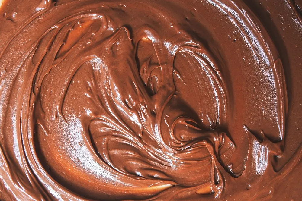 Rich and glossy chocolate ganache frosting made from melted chocolate and heavy cream, perfect for cakes, cupcakes, and desserts.