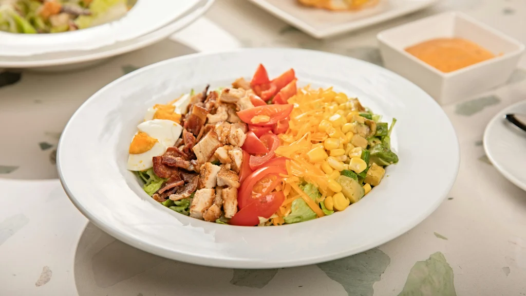 Healthy Cobb salad featuring chopped tomatoes, cucumbers, and hard-boiled eggs
