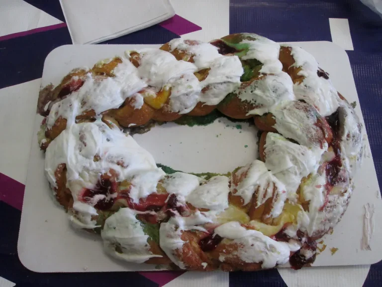 Authentic Randazzo’s-style King Cake decorated with purple, green, and gold sugars, ready for Mardi Gras celebration
