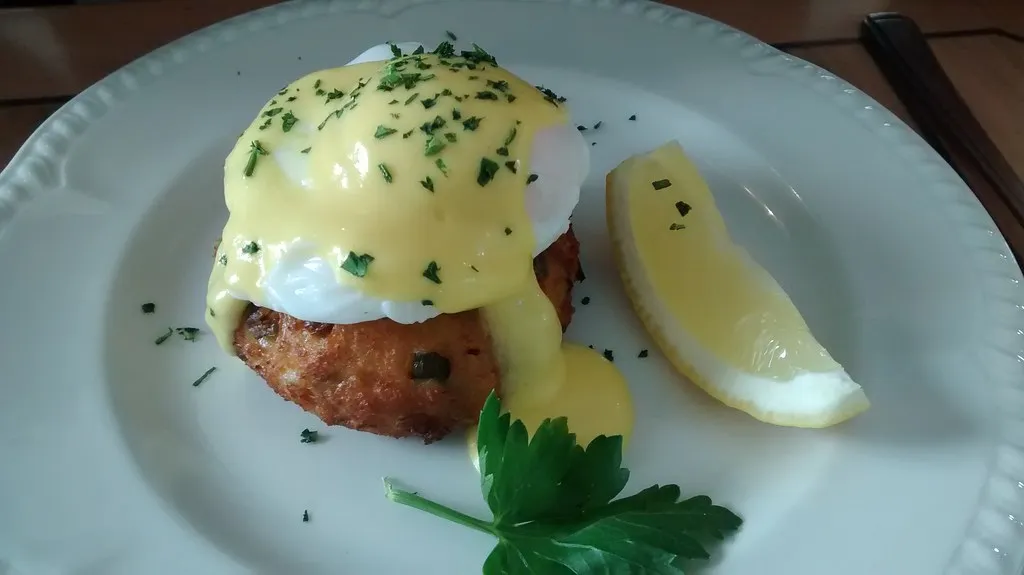 Crab Cake Eggs Benedict served on toasted English muffins with poached eggs and creamy hollandaise sauce