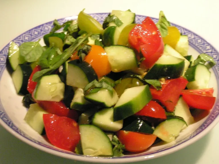 Fresh and vibrant tomato cucumber salad tossed with zesty lemon dressing in a white bowl