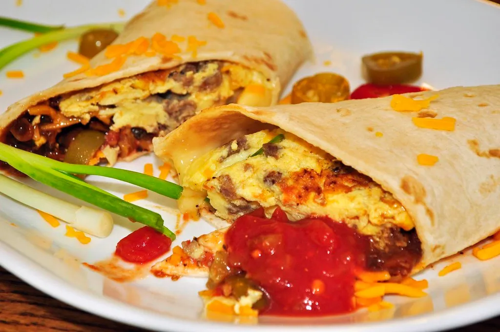 Golden and crispy breakfast burrito filled with scrambled eggs, bacon, and cheese