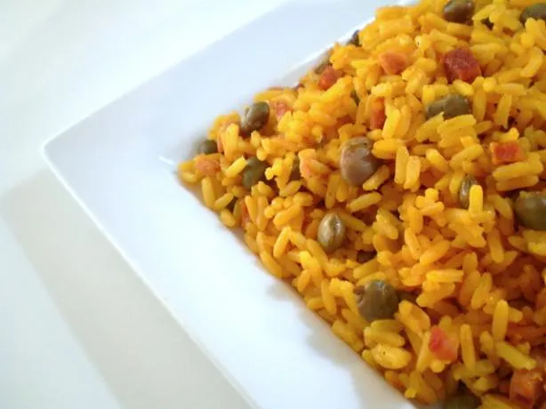 close-up of Arroz con Gandules served in a bowl, showing the fluffy rice and pigeon peas mixed with vibrant sofrito and achiote oil.