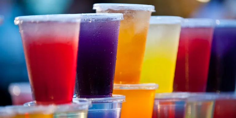 Refreshing loaded tea drink with vibrant layers, fresh fruits, and ice in a clear glass.