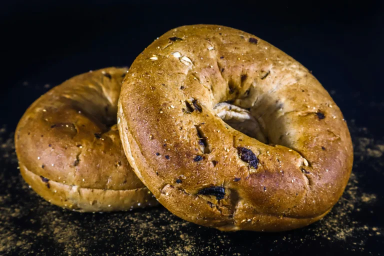 Warm homemade chocolate chip bagels on a baking tray, golden brown with visible melted chocolate chips.