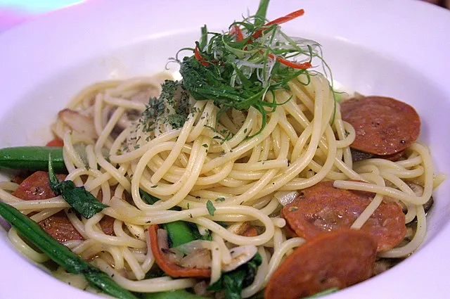 Hearty smoked sausage pasta with creamy sauce, garnished with fresh parsley and Parmesan cheese