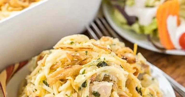 Creamy Monterey chicken spaghetti baked in a casserole dish with melted cheese and fresh herbs on top