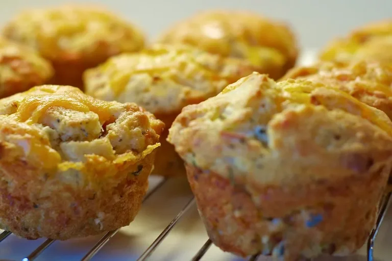Golden bacon and sausage egg muffins freshly baked in a muffin tin on a rustic wooden table