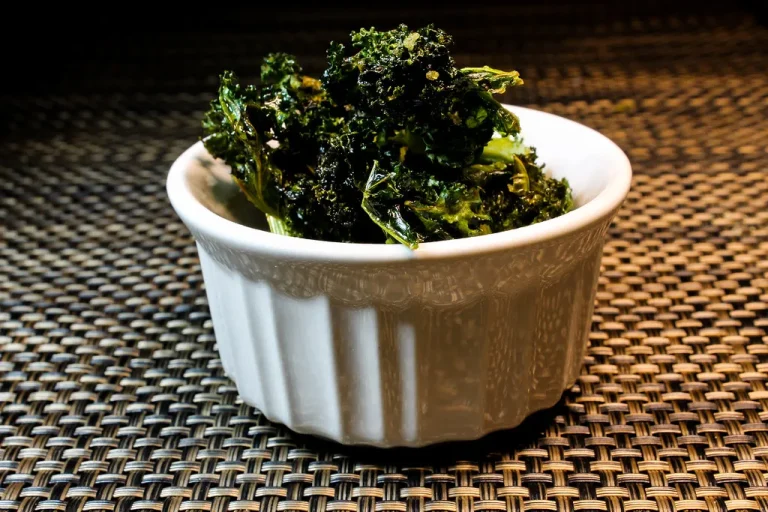Crispy air fried kale chips seasoned and served in a rustic bowl