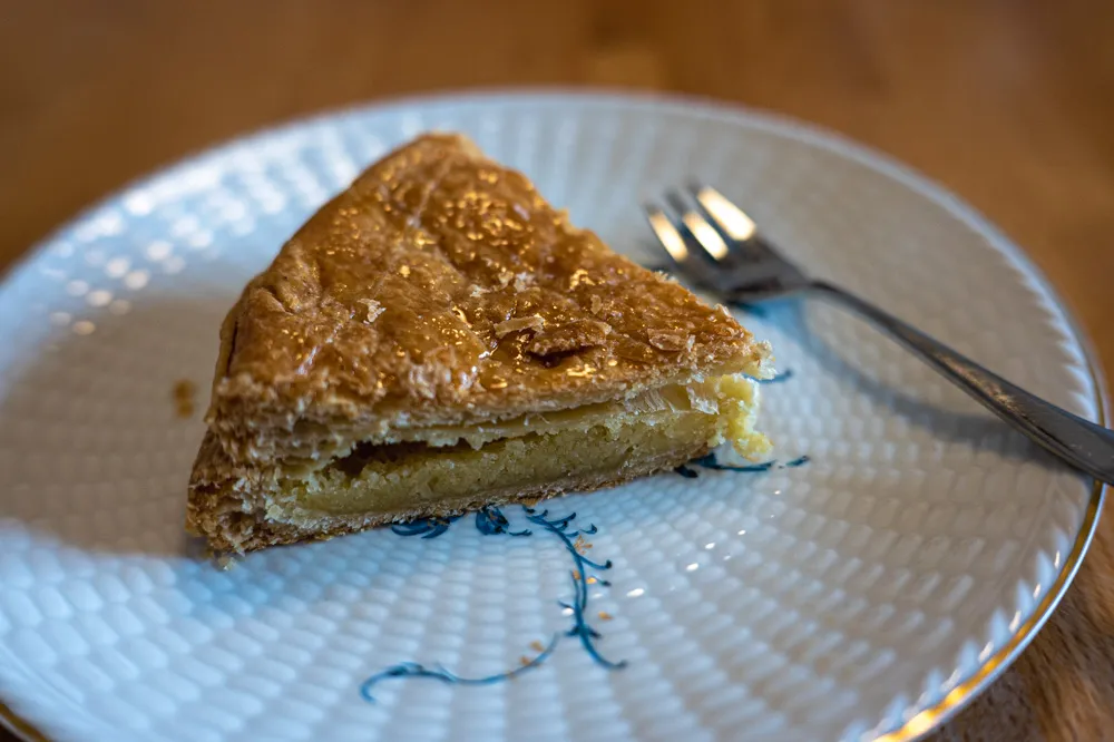Slice of Galette des Rois revealing creamy almond frangipane filling and hidden fève inside