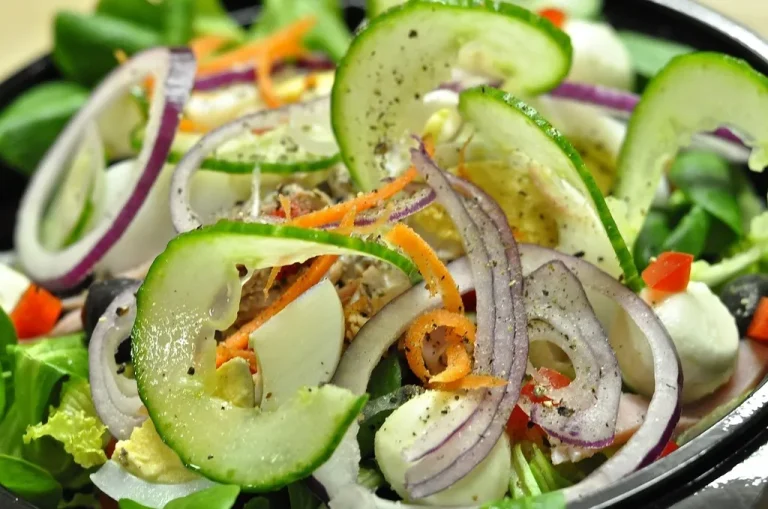 Refreshing cucumber onion salad with dill and tangy vinegar dressing in a white bowl”