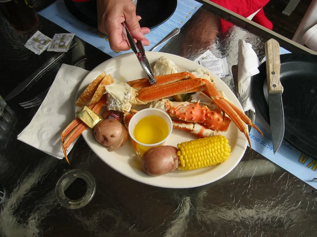 Snow crab boil with red potatoes, corn on the cob, and smoked sausage served on a rustic wooden table