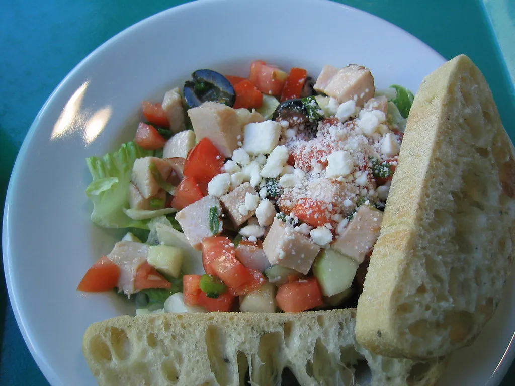 Homemade turkey salad with celery, cranberries, and creamy dressing in a white bowl