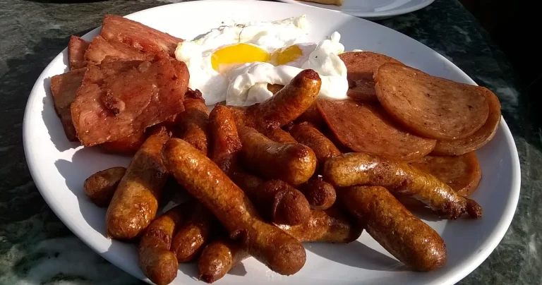 Homemade pork breakfast sausage patties cooked to golden brown and served on a rustic plate with eggs and toast”