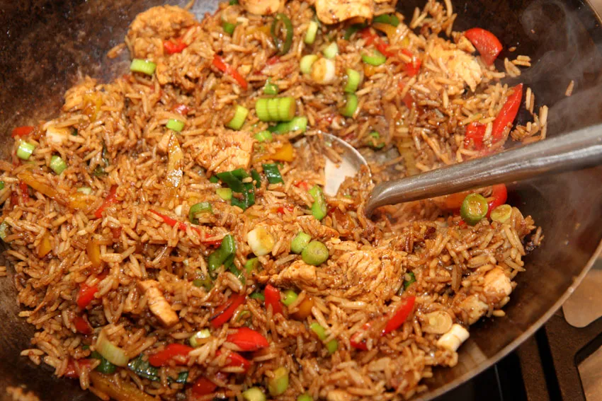 Overhead shot of Chinese fried rice in a wok with vegetables, egg, and green onions