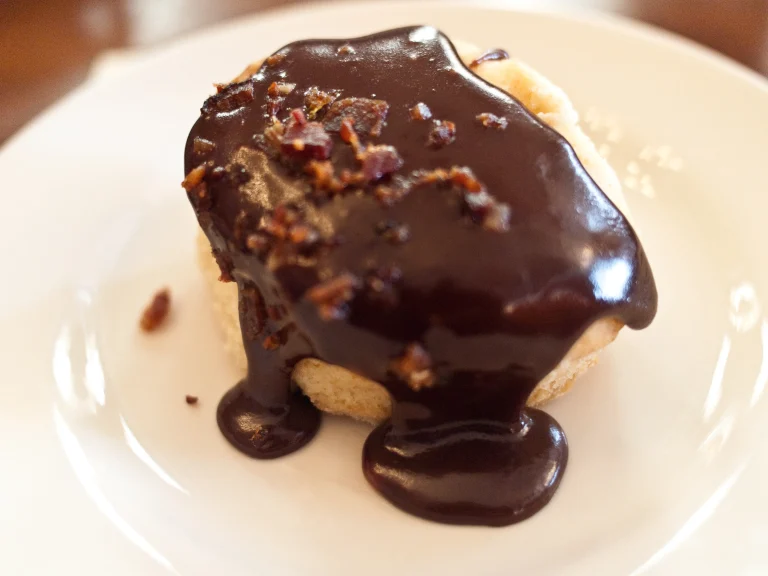 Southern-style biscuits topped with warm, rich chocolate gravy served on a plate, perfect for a cozy breakfast or brunch.