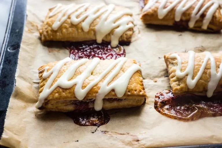 Homemade chocolate toaster strudel with golden flaky crust and drizzled icing on a white plate
