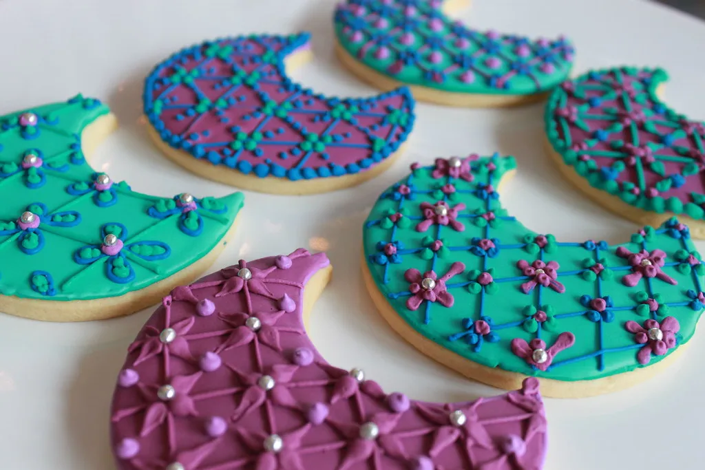 Homemade moon-shaped cookies decorated with pastel icing and edible glitter