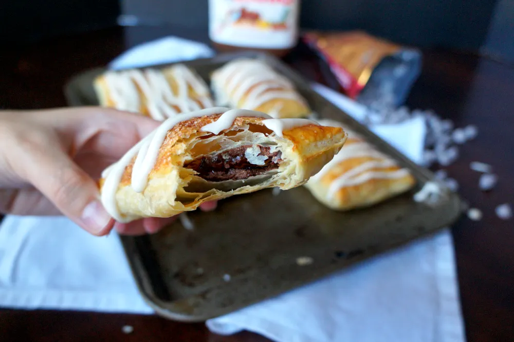 Rolling out puff pastry dough on a floured surface for homemade chocolate toaster strudel