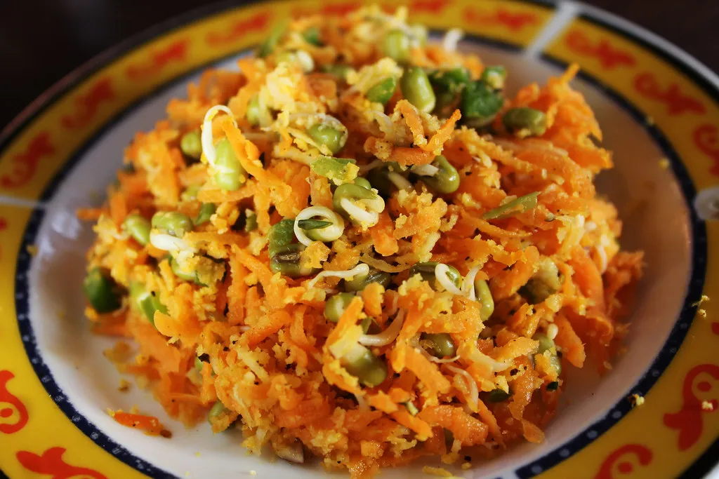 Close-up of freshly shredded carrots in a bowl, ready for salad preparation