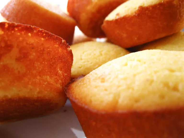 Soft and golden honey cornbread muffins on a cooling rack, drizzled with honey and ready to serve
