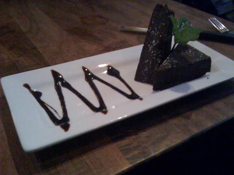 Flourless chocolate torte dusted with cocoa powder on a serving plate