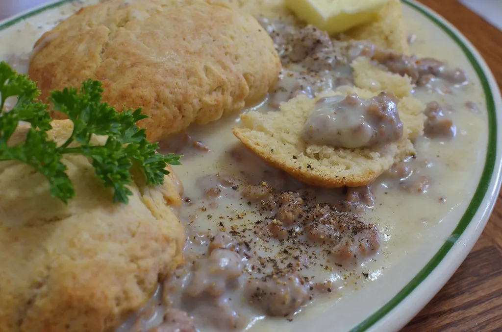 Fluffy vegan biscuits with creamy mushroom gravy on plate.