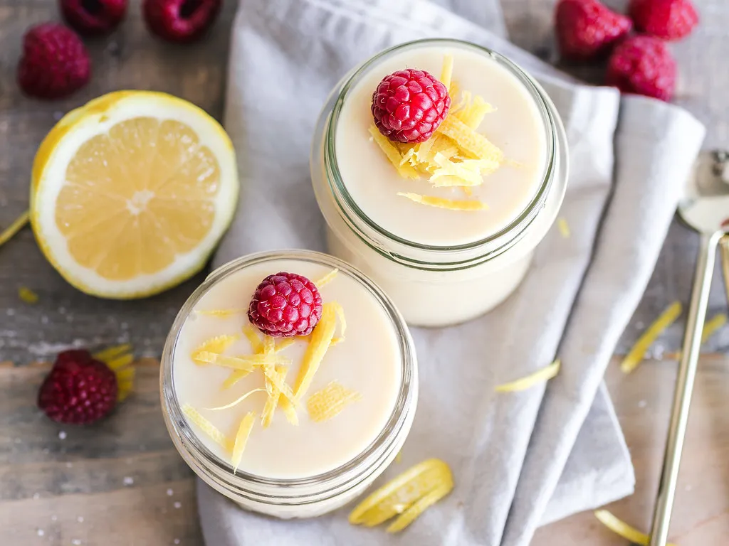 Creamy lemon mousse served in glass cups topped with fresh berries and mint leaves
