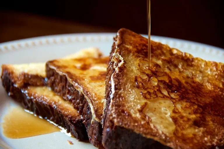 Extra-custardy French toast with golden edges, creamy interior, and fresh berries on a brunch plate